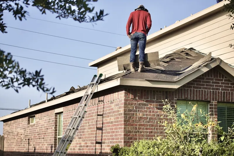 Professional roofer working on a residential roof in Turner Village